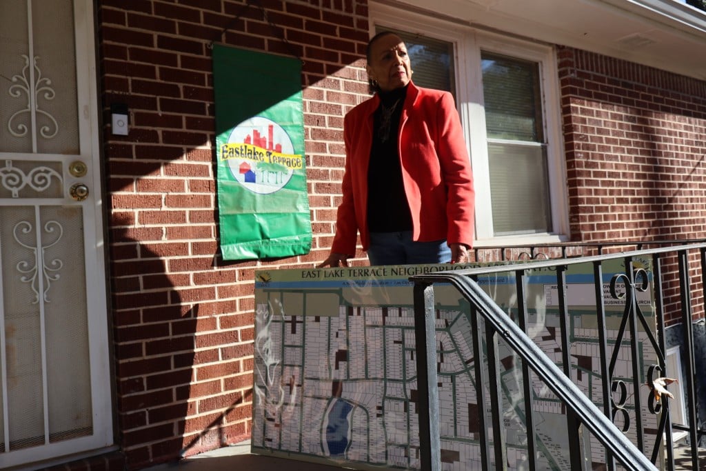 Brenda Pace stands in front of her East Lake Terrace home with a map she made of her community’s demographics for the East Lake Terrace Neighborhood Association. (Zoey Laird)