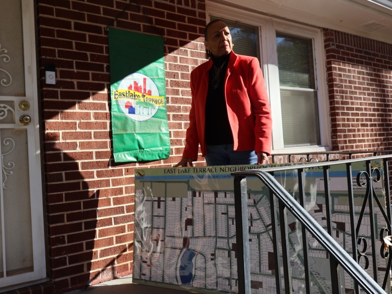 Brenda Pace stands in front of her East Lake Terrace home with a map she made of her community’s demographics for the East Lake Terrace Neighborhood Association. (Zoey Laird)