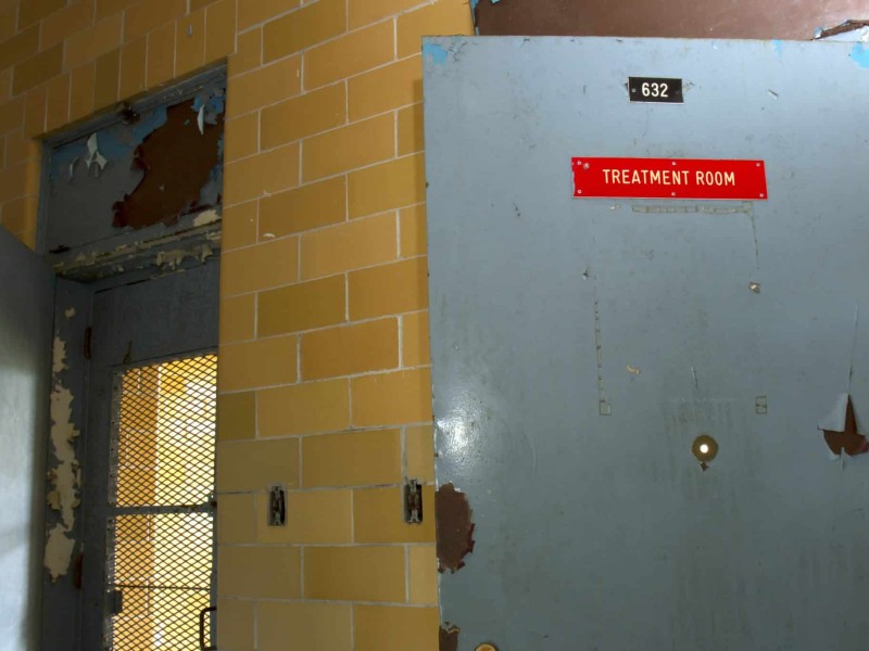 Door marked treatment room in hallway of old institution.