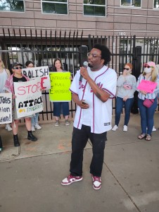 Brandon of Atlanta Alliance Against Racism and Political Repression speaks on the similar conditions migrants, Palestinians and Black Americans face from state repression. (Zak Kerr)