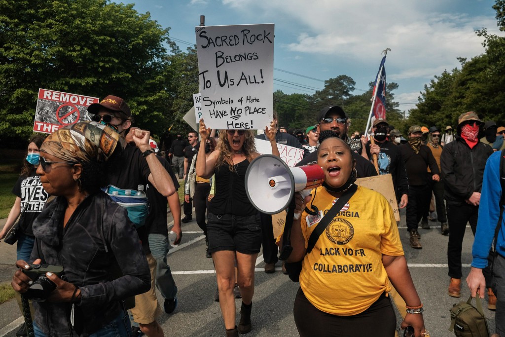 A group of protesters make their way toward the 2022 Confederate Memorial Day rally at Stone Mountain Park in Stone Mountain, Georgia.