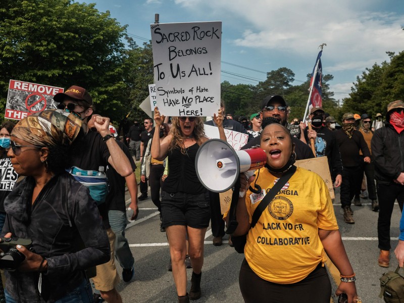 A group of protesters make their way toward the 2022 Confederate Memorial Day rally at Stone Mountain Park in Stone Mountain, Georgia.