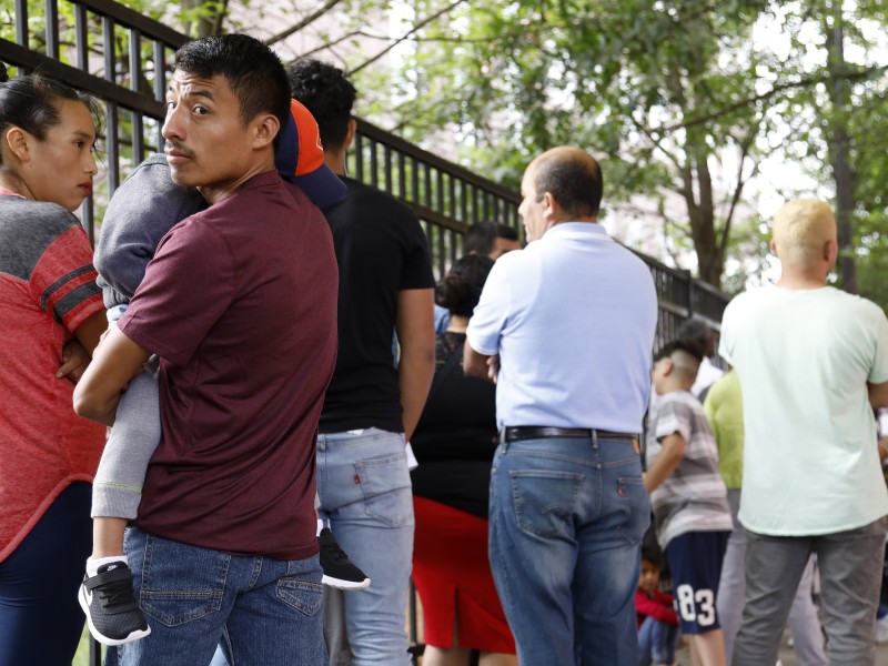 Auner Cobon holds his son Andry while waiting in line outside the building that houses Immigration and Customs Enforcement and the Atlanta Immigration Court, in Atlanta