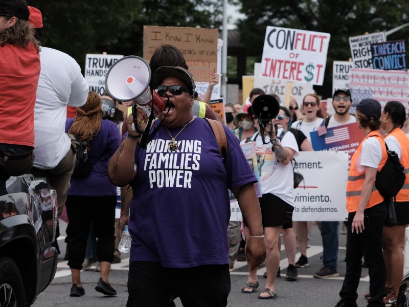 Sy Moore, an organizer with the Working Families Party, shouts into a megaphone during a workers' march on International Workers Day in Downtown Atlanta.