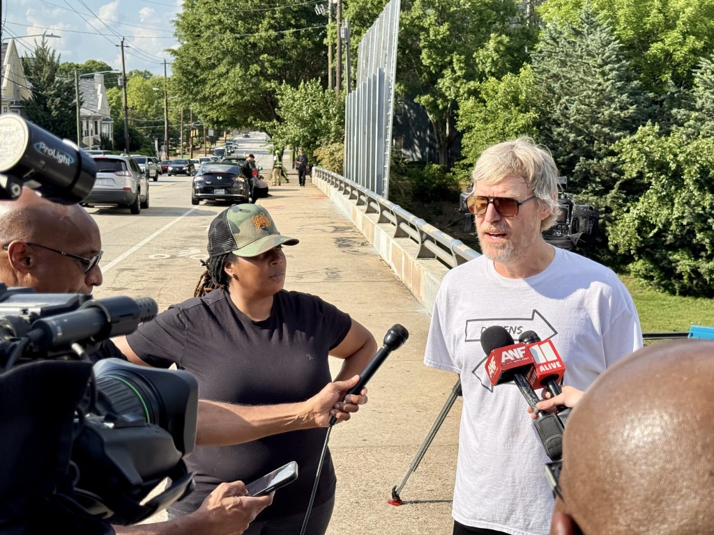 Mary Hooks and Tim Franzen of the People's Campaign to Stop Cop City speak to press conference during a protest in response to the Cop City ribbon cutting.