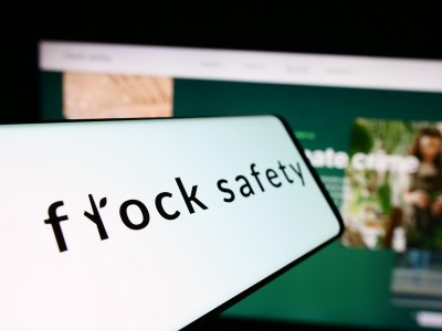 Cellphone with logo of American video surveillance company Flock Safety in front of business website. Focus on center-left of phone display. Atlanta police have used Flock cameras in immigration-related searches.