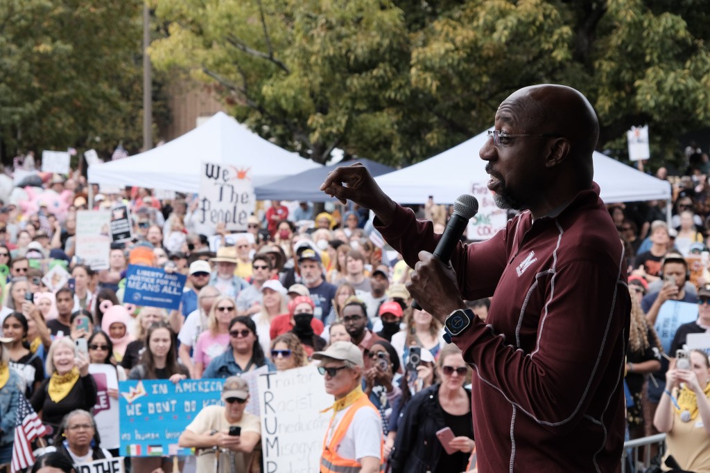 U.S. Senator Raphael Warnock addresses a crowd of people at the second No Kings rally.