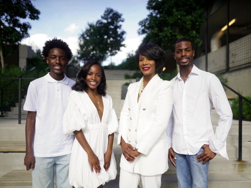 A family of four wearing all white and smiling into the camera.
