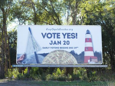 A billboard that says "VOTE YES! JAN 20" with a line below that reads "EARLY VOTING BEGINS DEC. 29TH." The billboard links to keepsapelogeechee.com