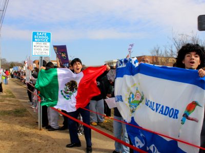Students from Central Gwinnett High School stand on the sidewalk outside the school building on Jan. 30, 2026, as part of a nationwide student walkout over ICE actions in Minneapolis and other cities across the country. (Maya Omar)