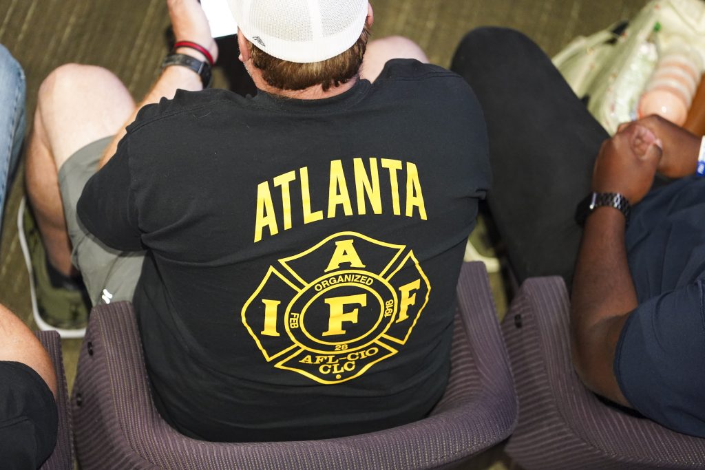 A member of the International Association of Firefighters listens to public comment during an Atlanta City Council meeting at City Hall in Atlanta, Ga on April 21, 2026. (Megan Varner / ACPC)